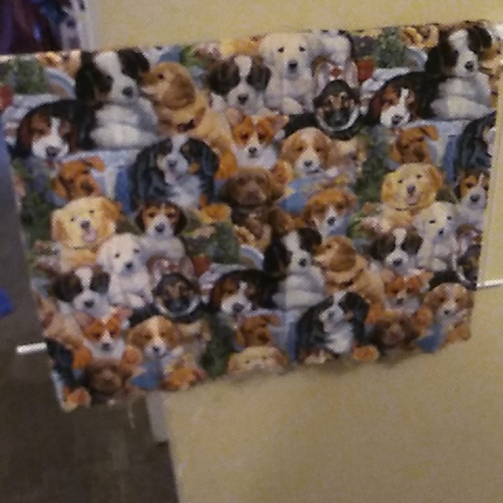 A piece of fabric that has puppies and dogs on it